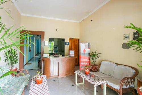 a living room with a couch and some plants at RedDoorz Syariah @ Sakinah Guesthouse in Sragen