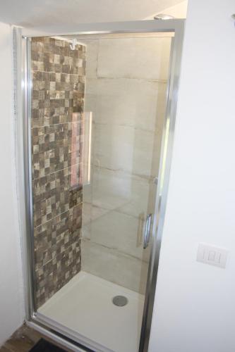 La salle de bains est pourvue d'une douche avec une porte en verre. dans l'établissement L'ALPACA DELLA ROSSA - AGRITURISMO, à Genga