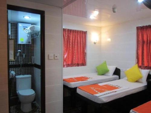 a bathroom with two beds and a toilet at Ashoka Hostel in Hong Kong