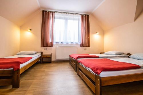 a room with two beds and a window at Dom Wypoczynkowy Modrys in Zawoja