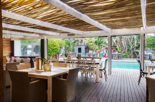 a restaurant with tables and chairs and a pool at Cape St Francis Resort in Cape St Francis