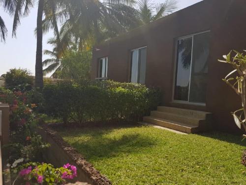 a house with stairs and flowers in front of it at Hotel Jardin Savana Dakar in Dakar