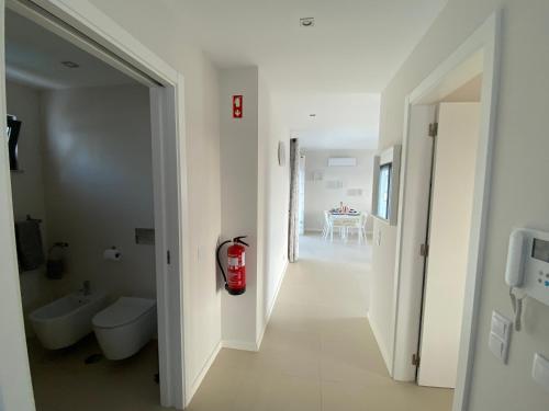 a white bathroom with a fire hydrant in the hallway at Albur Village B - Gerbera in Alvor