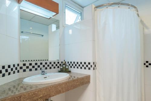ein Bad mit einem Waschbecken und einem Spiegel in der Unterkunft New Siam III Guest House in Bangkok