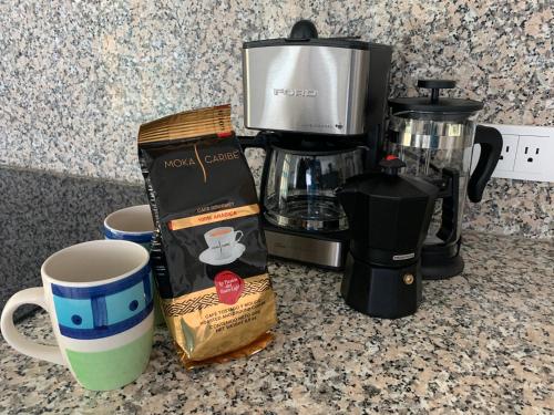 a coffeemaker and a box of coffee on a counter at Cimarron Suites Playa Parguito in Aricagua