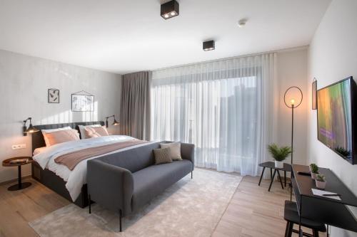 a bedroom with a large bed and a couch at Qstay Good Living Apartments in Antwerp