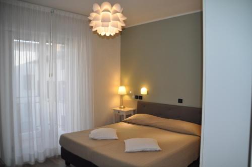 a bedroom with a bed with two white pillows at Hotel Regina in Grado