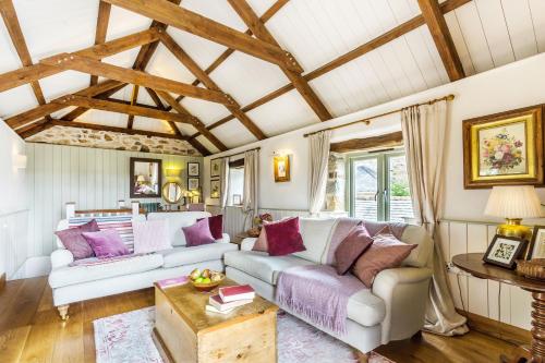 a living room with a couch and a table at Pear Tree Barn - Amazing Country views - Pet friendly - Balcony in Newquay