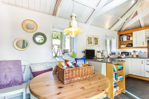 a kitchen with a wooden table with a basket on it at Pear Tree Cottage in Newquay