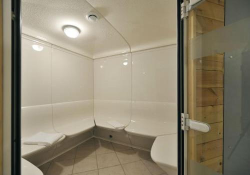 La salle de bains blanche est pourvue d'une douche et de toilettes. dans l'établissement Les Hauts Valmeinier, à Valmeinier