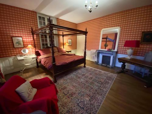 een slaapkamer met een hemelbed en een open haard bij Le Castel Ecossais in Senlis