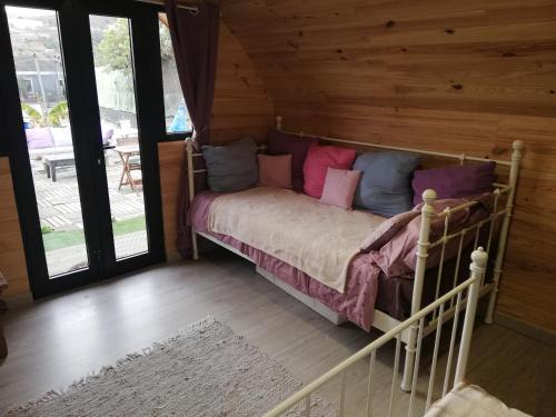 Un dormitorio con una cama en una cabaña de troncos en Casita de Verde, en Santa Cruz de Tenerife