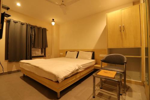 ein Schlafzimmer mit einem Bett und einem Stuhl darin in der Unterkunft HOTEL PRATAP GRAND in Ranchi
