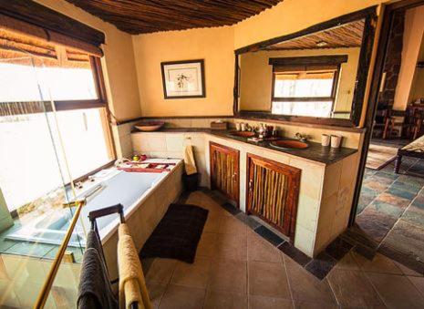 a kitchen with a tub and a sink in a room at Metsi Lodge in Welgevonden Game Reserve