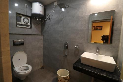 ein Badezimmer mit Waschbecken, Toilette und Spiegel in der Unterkunft HOTEL PRATAP GRAND in Ranchi