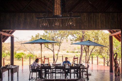 two people sitting at a table under umbrellas at Metsi Lodge in Welgevonden Game Reserve