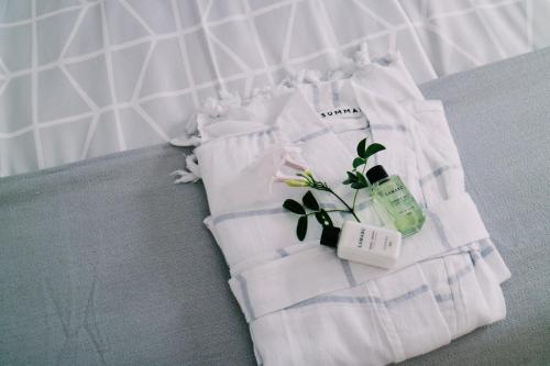 a white towel with a plant and a bottle on it at 9 Windsor House in Tokai