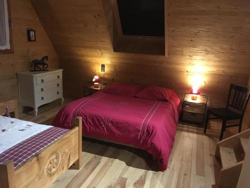 1 dormitorio con 1 cama con edredón rojo y silla en La cavalièra, en Polminhac