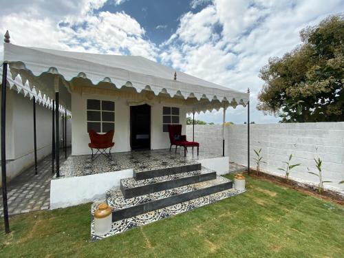 a small white house with a white roof and stairs at 16 Bedouin Private Pool Villa in Hosūr