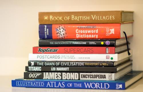 a stack of books sitting on a shelf at Dale Street Apartments Suite in Leamington Spa