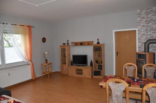 a living room with a table and a television at Flora in Galenbeck