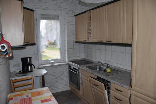 a kitchen with wooden cabinets and a sink and a window at Flora in Galenbeck