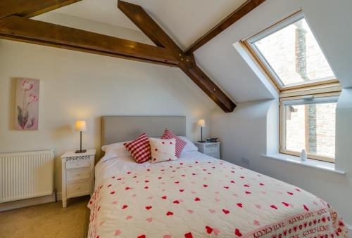 a bedroom with a large bed and a window at Birchill Farm & Cottages - Bramble Cottage in Great Torrington