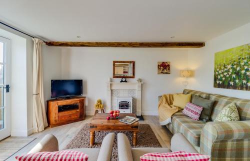 a living room with a couch and a tv at Birchill Farm & Cottages - Bramble Cottage in Great Torrington