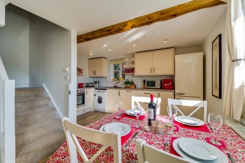 a dining room with a table and chairs and a kitchen at Birchill Farm & Cottages - Bramble Cottage in Great Torrington