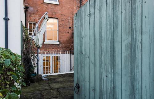 a wooden fence in front of a brick building at Dale Street Apartments Suite in Leamington Spa