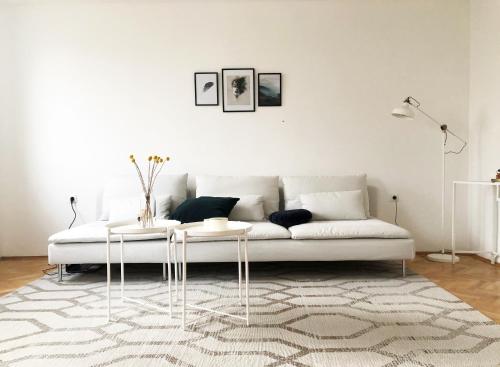 a living room with a white couch and a rug at Alva Apartment in Niš