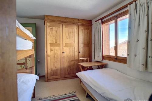 a bedroom with two bunk beds and a window at Gaiola 1er in Bagnes