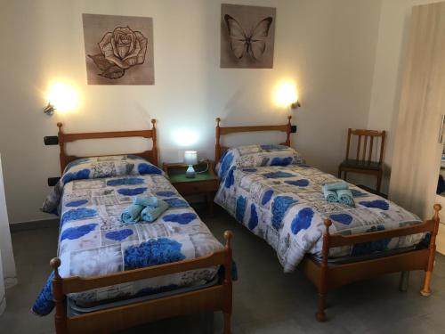 a bedroom with two beds and a butterfly on the wall at Casa jole in Assemini