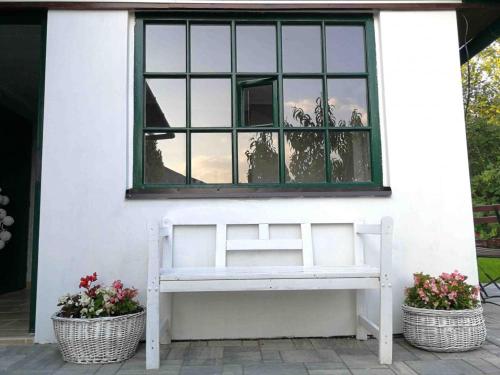 a white bench sitting in front of a window at Pension Brusenka in Bystřice pod Hostýnem