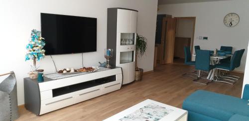 a living room with a flat screen tv on the wall at Apartment Sebiell in Vrchlabí