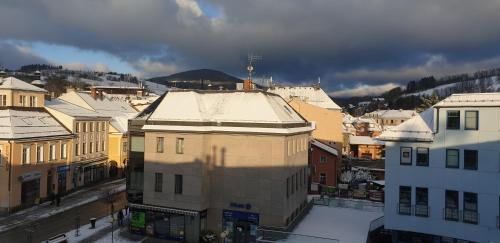 a city with snow on the roofs of buildings at Apartment Sebiell in Vrchlabí