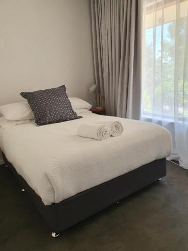 a bed with two pillows on it in a bedroom at Seacliff Park Holiday Home in Seacliff