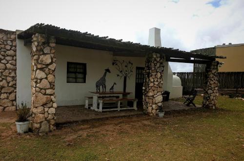 a house with a building with a giraffe on it at Thali Thali Game Lodge in Langebaan