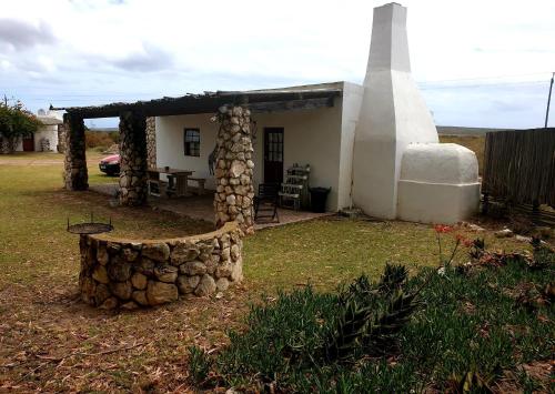 a small house with a pile of rocks in front of it at Thali Thali Game Lodge in Langebaan