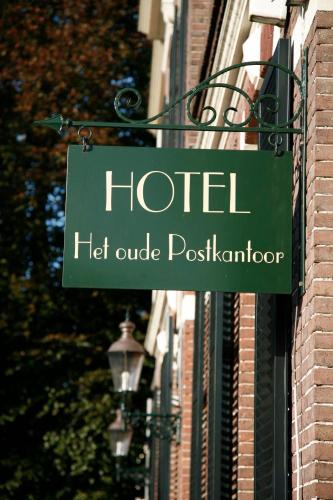 a green hotel sign hanging off the side of a building at Hotel het Oude Postkantoor in Brummen