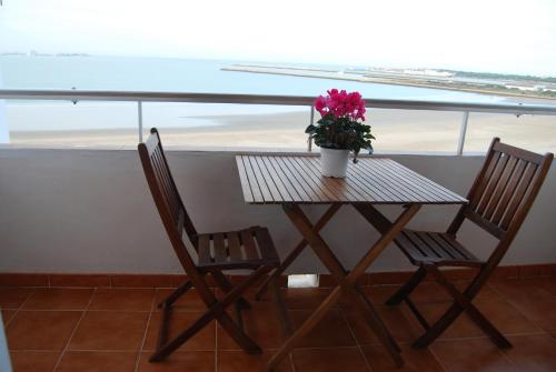 una mesa con dos sillas y una maceta en ella en La casa De Los Faros, en El Puerto de Santa María