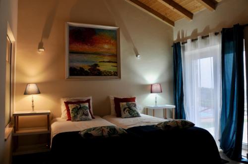 サン・ルイスにあるCal Velho - Holiday Lodgeのベッドルーム1室(ベッド1台付)が備わります。壁には絵画が飾られています。