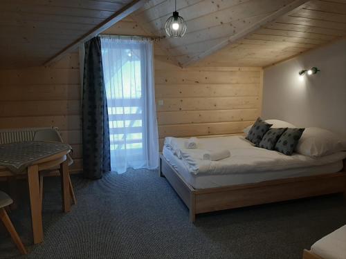 una camera da letto con un letto in una stanza con una finestra di Apartamenty i pokoje u Klimka a Zakopane