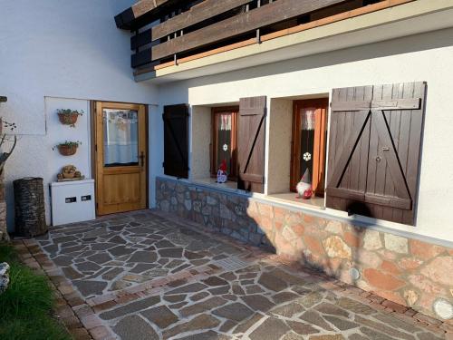 een huis met 2 deuren en een stenen patio bij La casa di Rosy in Enego