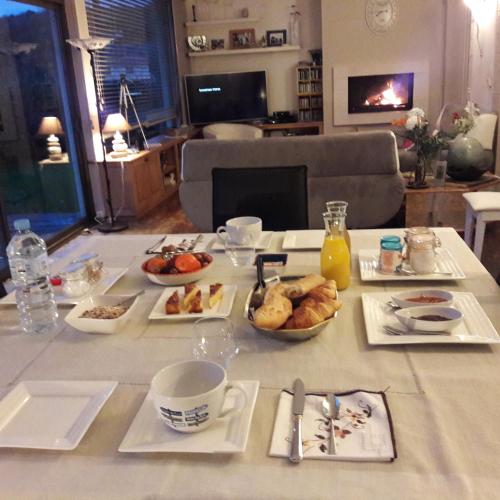 ドゥアルヌネにあるIzellaの食べ物の皿とコーヒーカップが置かれたテーブル