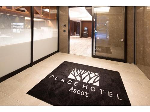 a black hotel absorb rug on the floor of a building at Place Hotel Ascot in Kumamoto
