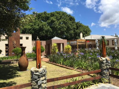 a garden with a fence and a vase in the yard at Lily Pond Country Lodge in The Crags