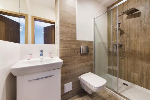a bathroom with a toilet and a sink and a shower at Pensjonat Orle in Krynica Zdrój