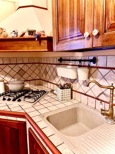 a kitchen with a sink and a stove at Casa Mimí in Cefalù