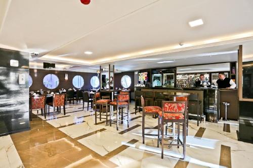 イタジャイにあるSandri Palace Hotelのレストランの赤い椅子付きのバー